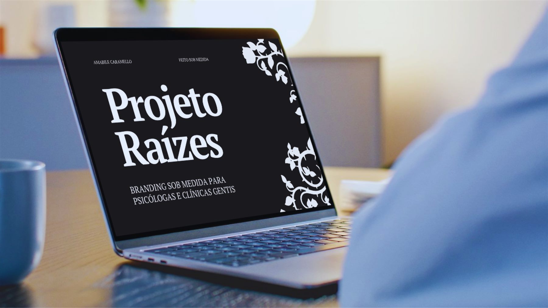 Mockup do Projeto Raízes em um laptop sobre uma mesa